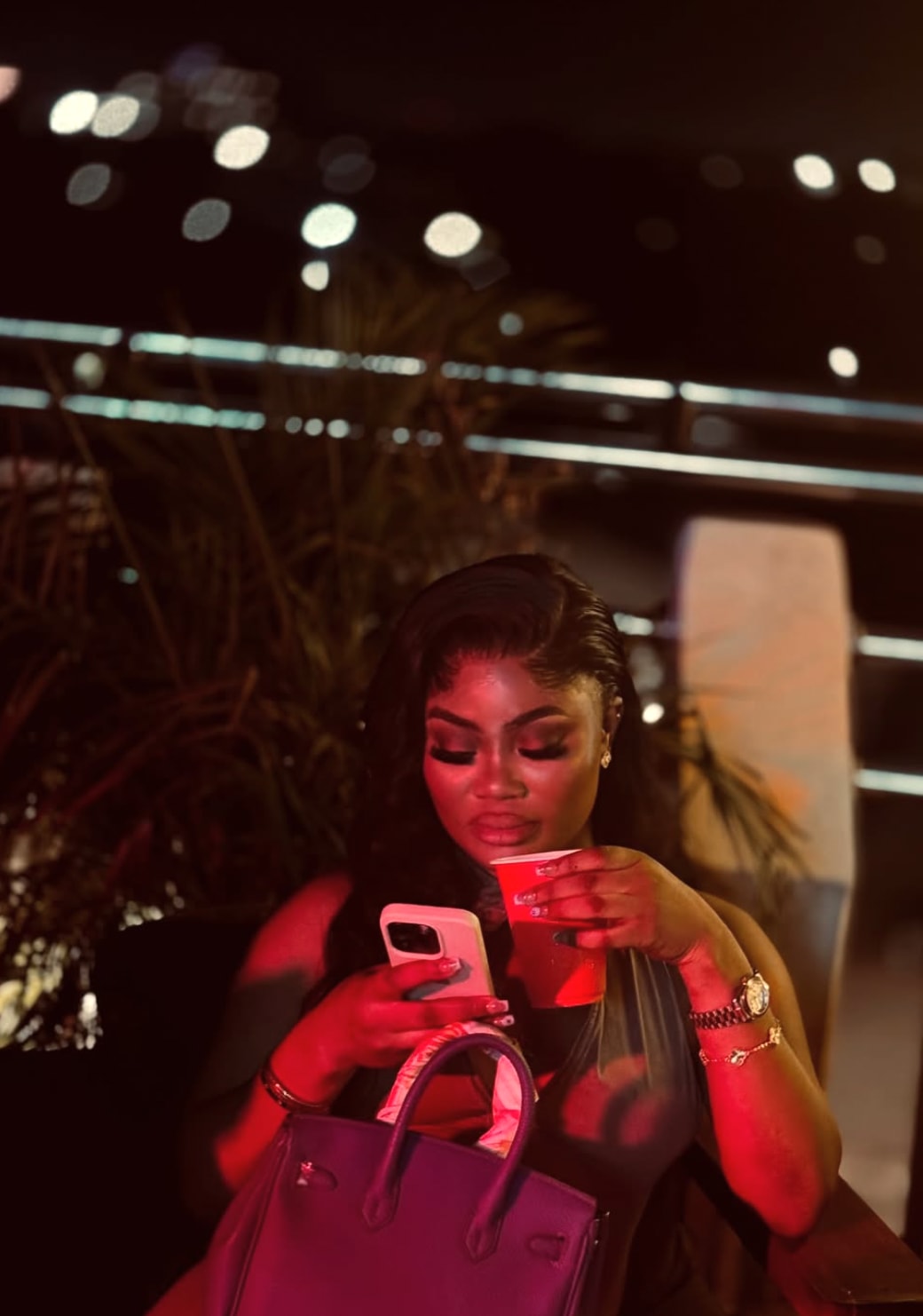 Guest seated at HILITE with a red drink under rooftop lounge lighting