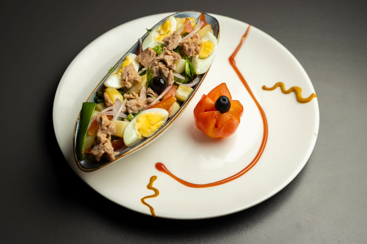 HILITE plated brunch starter with eggs, tuna, vegetables, and tomato garnish