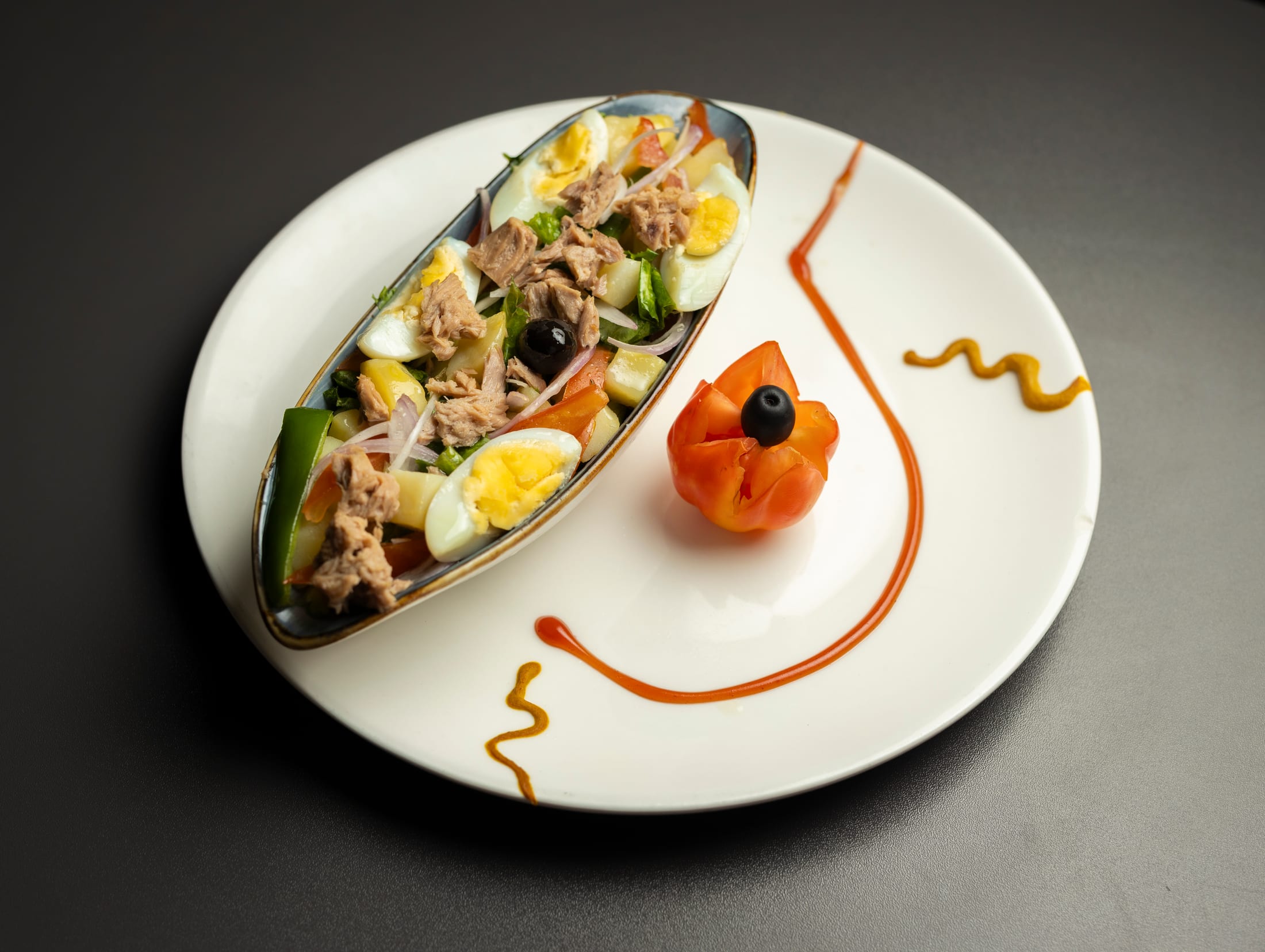 HILITE plated brunch starter with eggs, tuna, vegetables, and tomato garnish