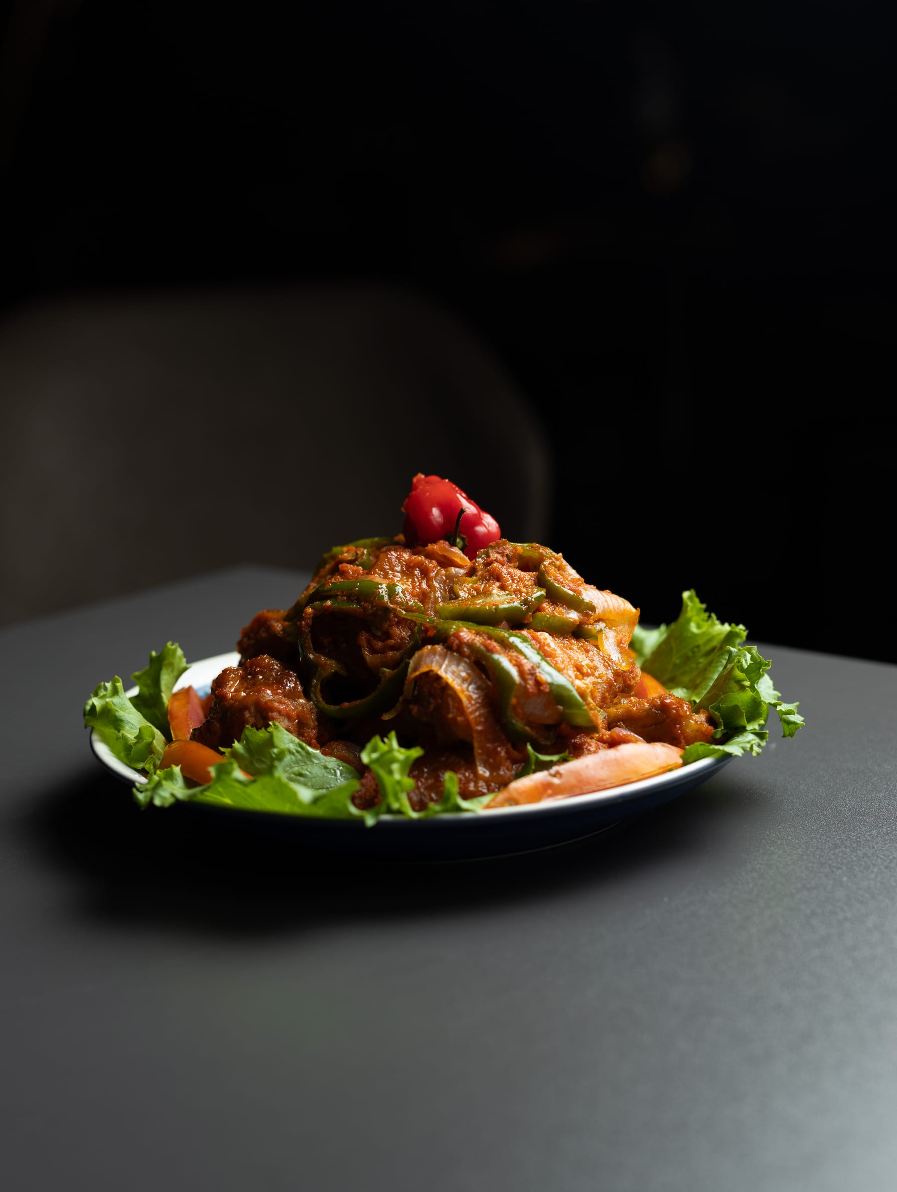 HILITE signature dish with peppers, onions, and fresh greens